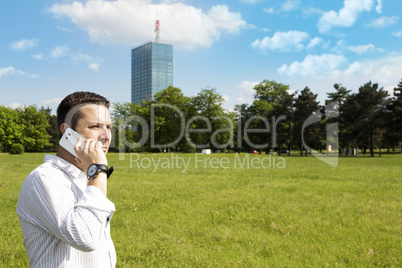 Successful Businessman Talking On The Phone In The Park With Cor