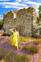 Woman in lavender field in front of old ruin