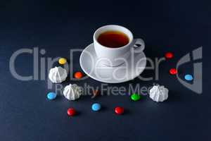 Cup tea and sweets on dark background