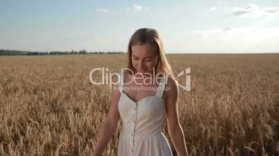 Blissful beautiful woman walking in cereal field