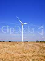Windmill in a field against a blue sky