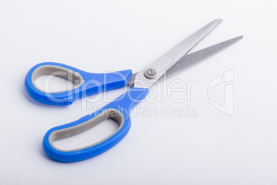 A half open pair of scissors with a blue grip