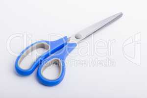 A closed pair of scissors with a blue grip