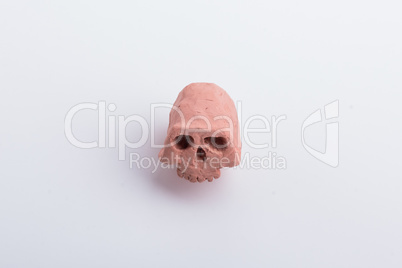 A part of a skull made from orange clay