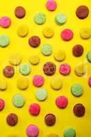 Colored almond cookies on a yellow background