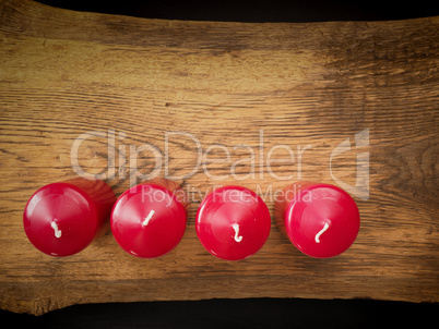 Four red candles on wood