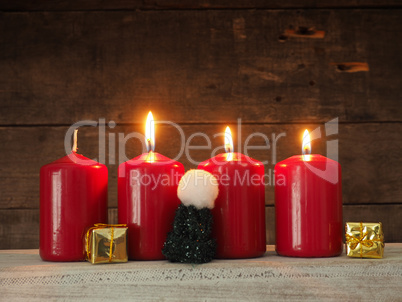 Four red Advent candles on wood
