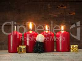 Four red Advent candles on wood