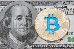 Golden cryptocurrency blue bitcoin on hundred dollar.