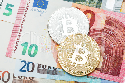 Silver and golden Bitcoin close-up. Euro currency as a backgroun