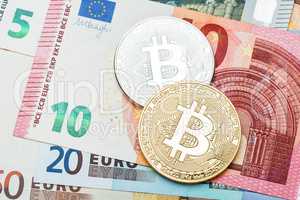Silver and golden Bitcoin close-up. Euro currency as a backgroun