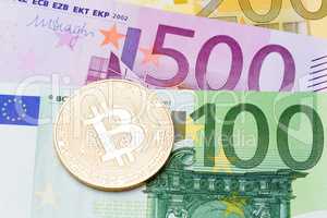 Close up of golden bitcoins on euro currency background.