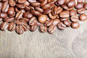 Freshly natural roasted coffee beans over textured wooden backgr