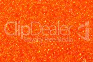 Close up photograph of yellow seed beads background.