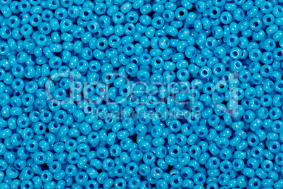 Multicolored blue glass seed beads background.