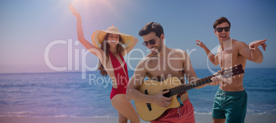 Composite image of friends playing music in swimwear