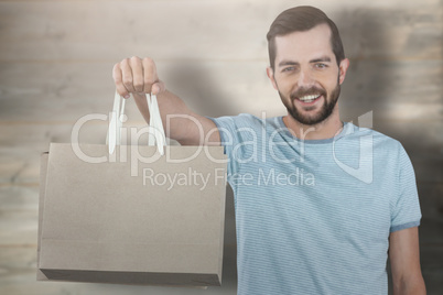 Composite image of portrait of smiling man showing shopping bag