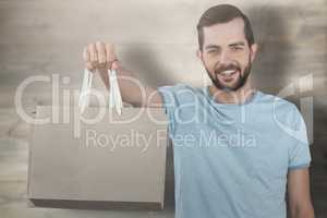 Composite image of portrait of smiling man showing shopping bag