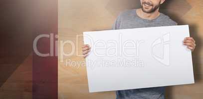 Composite image of portrait of happy young man holding placard