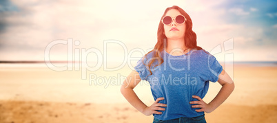 Composite image of confident female model wearing sunglasses standing with hands on hip