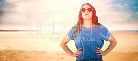 Composite image of confident female model wearing sunglasses standing with hands on hip