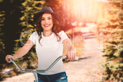 Composite image of portrait of happy woman cycling on bicycle