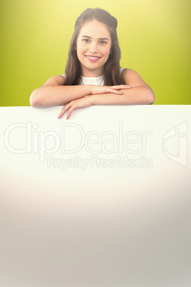 Composite image of beautiful brunette women holding blank poster