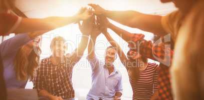 Cheerful business people giving high five while sitting creative office