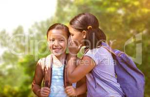 Composite image of girl with backpack whispering in friend ear