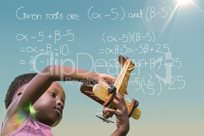 Composite image of playful boy holding toy airplane