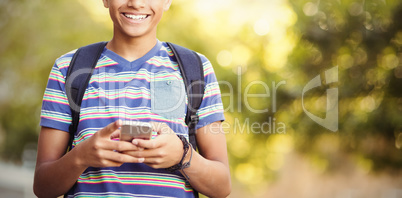 Schoolboy using mobile phone in campus at school