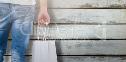 Composite image of mid section of man carrying shopping bag