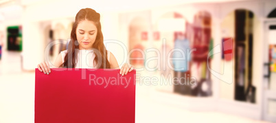 Composite image of beautiful brunette women holding blank poster