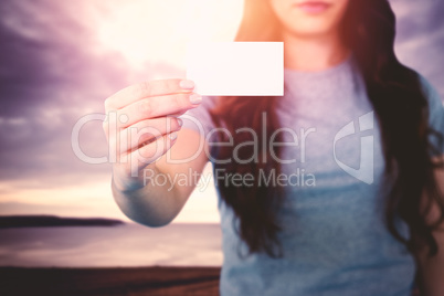 Composite image of woman holding blank card Composite image of woman holding blank card