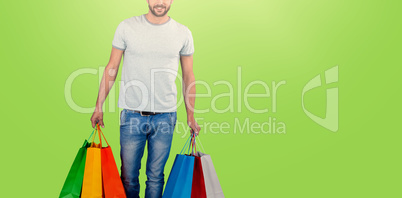 Composite image of portrait of young man carrying colorful shopping bag against white background