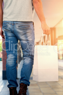 Composite image of low section of man carrying shopping bag