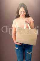 Composite image of brunette women holding blank bag with copy space