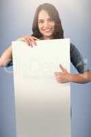 Composite image of brunette women holding blank poster