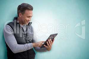 Composite image of mature man surfing the internet on his tablet