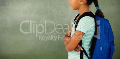 Young girl with her arms crossed against chalk board