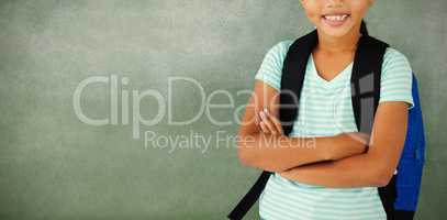 Portrait of cute school girl standing with arms crossed