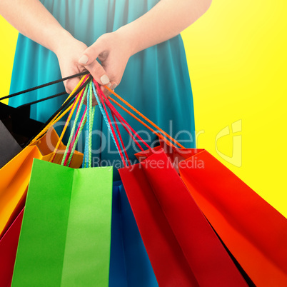 Composite image of beautiful brunette women holding bags
