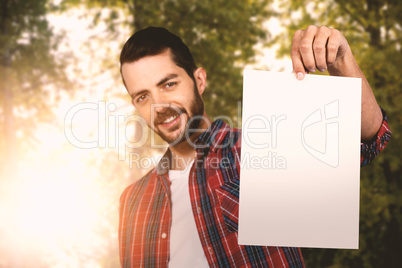 Composite image of portrait of confident young man showing cardboard