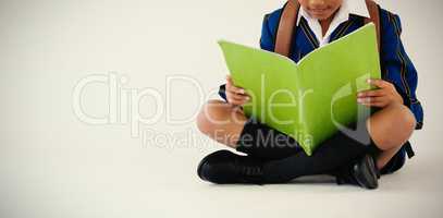 Schoolboy reading book on white background