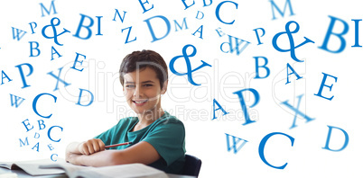 Composite image of portrait of boy doing homework