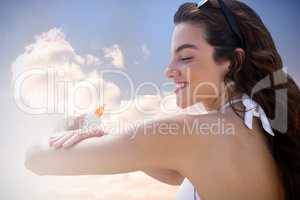 Composite image of beautiful women applying suncream