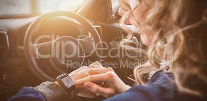 Close up of woman using smart watch in car