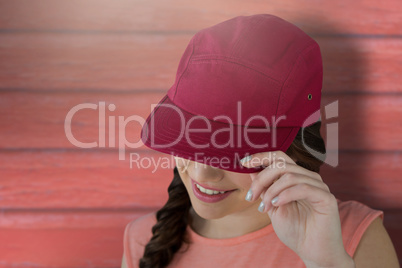 Composite image of smiling female model showing red cap
