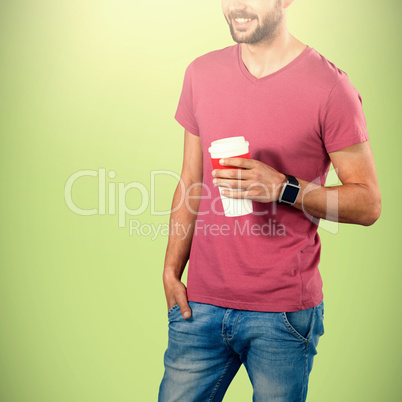 Composite image of midsection of smiling model holding disposable coffee cup