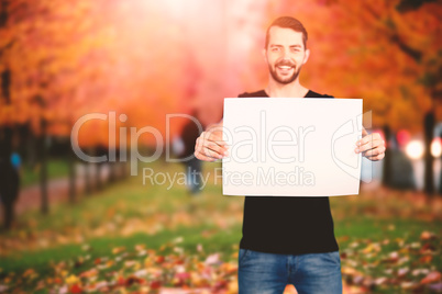 Composite image of portrait of happy man showing blank cardboard